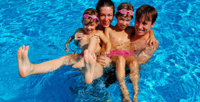 A family of four playing in the pool