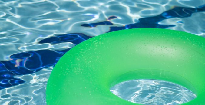 A green inflatable balloon on the pool