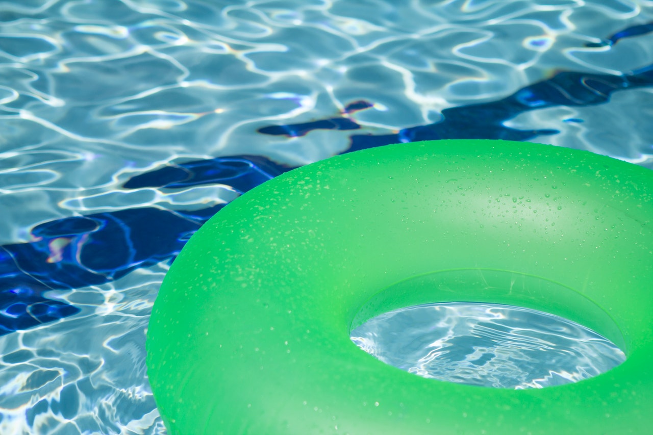 A green inflatable balloon on the pool