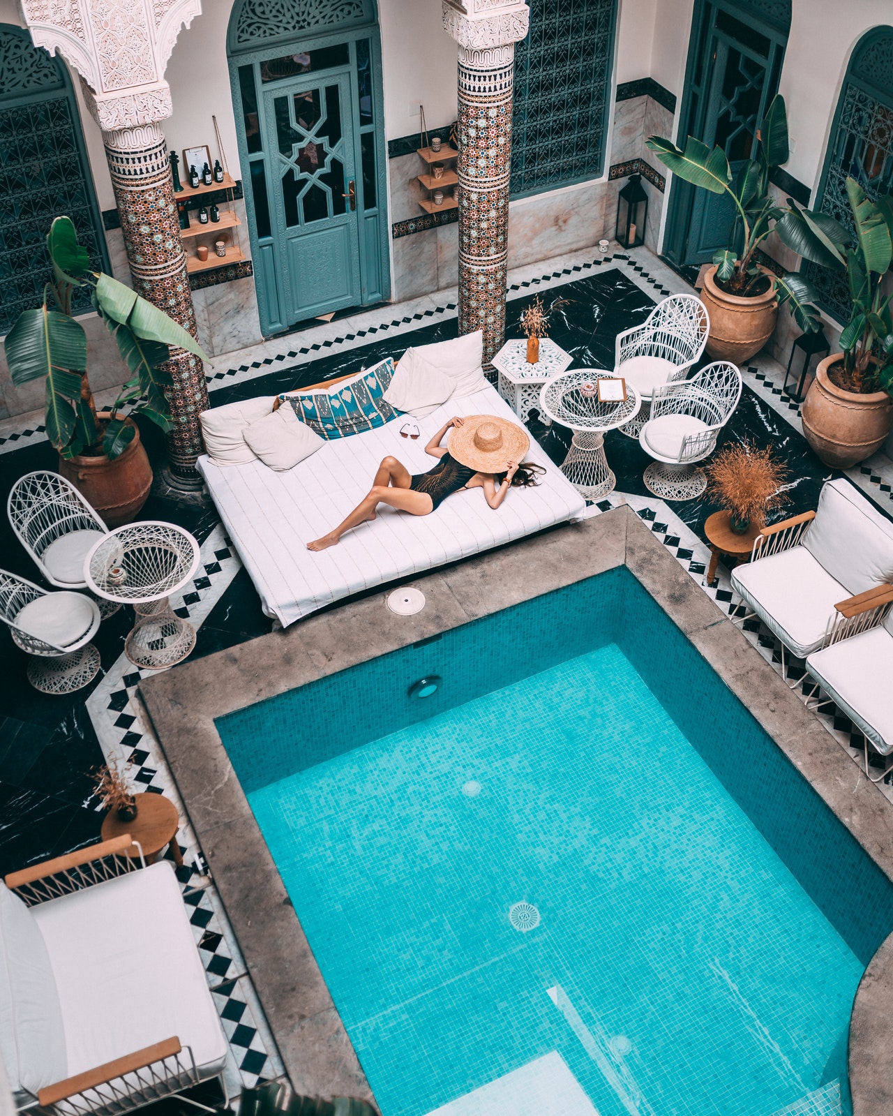 A pool inside a house with a woman sleeping on the side