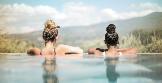 two women in the pool with mountains in the background