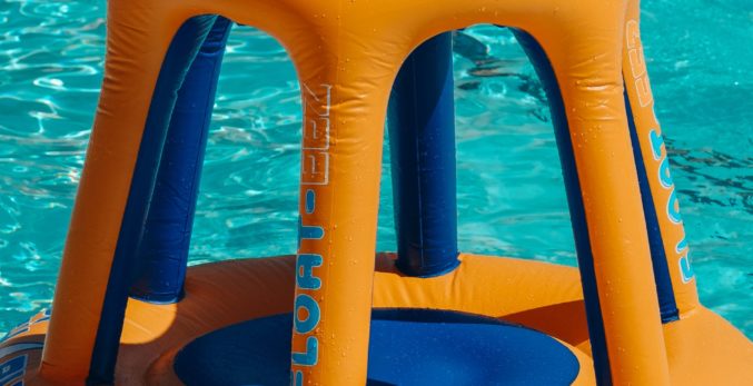 An orange and blue inflatable float sitting in a pool.