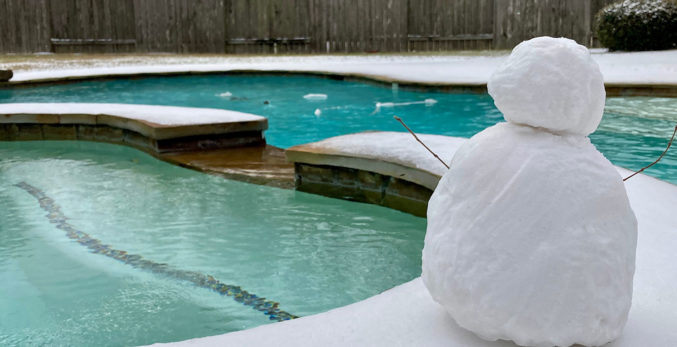 A pool in winter with a snow man in front